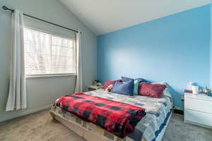 The primary bedroom features a gorgeous tree that offers privacy and still lets in the natural light. The cathedral ceiling gives a spacious feel.