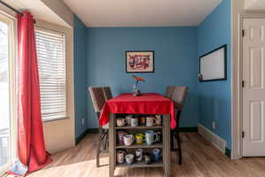 Dining area featuring baseboards, visible vents, and wood finished floors