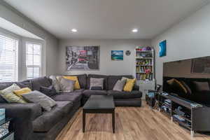 Living area with light wood-style flooring, crown molding, and recessed lighting