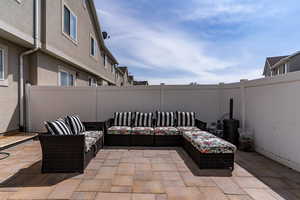 View of patio with an outdoor hangout area and a fenced backyard