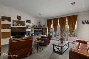 Living area with visible vents, recessed lighting, lofted ceiling, and carpet flooring