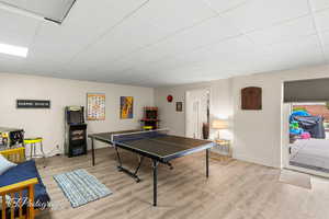 Playroom with a drop ceiling, baseboards, and wood finished floors