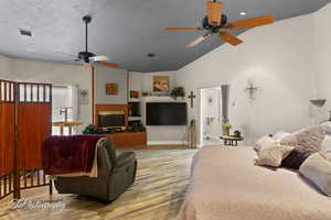Living room with a ceiling fan, wood finished floors, a textured ceiling, and visible vents