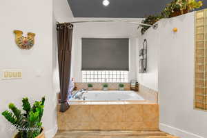 Bathroom featuring a bath and wood finished floors