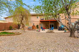 Back of property featuring stucco siding, fence, and a patio area