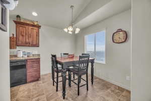 Dining area with baseboards, lofted ceiling, a notable chandelier, and recessed lighting