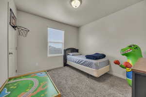 Carpeted bedroom with baseboards, visible vents, and a textured ceiling