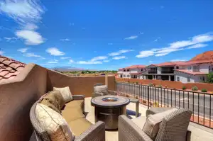 View of patio with a balcony, an outdoor living space with a fire pit, and a residential view