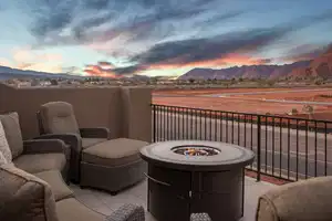 Patio terrace at dusk featuring a balcony and a mountain view