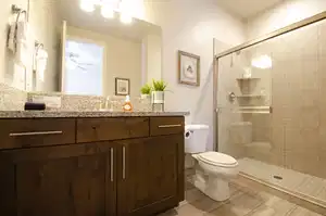 Full bathroom featuring vanity, ceiling fan, toilet, and a shower stall
