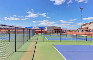 View of tennis court featuring a mountain view and fence