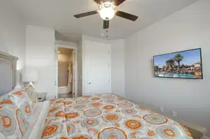 Bedroom featuring ensuite bath and a ceiling fan