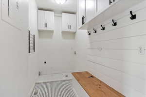 Mudroom with baseboards and electric panel
