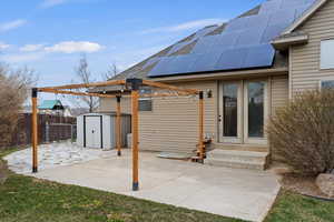 View of patio / terrace with a fenced backyard, an outbuilding, a shed, and entry steps