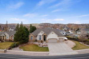 French country style house with stucco siding, a garage, concrete driveway, and a front yard