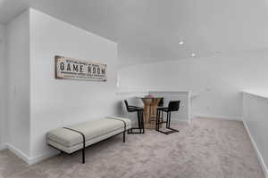Living area with an upstairs landing, carpet, baseboards, and recessed lighting