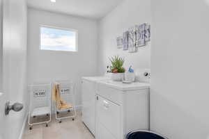 Bathroom featuring baseboards, washing machine and dryer, and tile patterned flooring