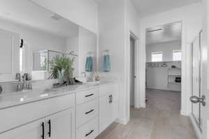 Full bathroom featuring double vanity, a sink, a walk in closet, and a shower stall