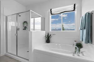 Full bathroom featuring a bath and a shower stall