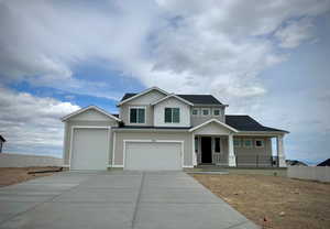 Craftsman house with covered porch, driveway, fence, and a garage