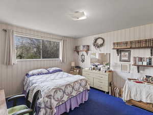 Carpeted bedroom featuring wallpapered walls