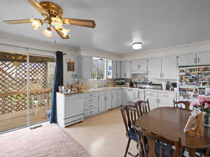 Kitchen with white appliances, visible vents, light countertops, and under cabinet range hood