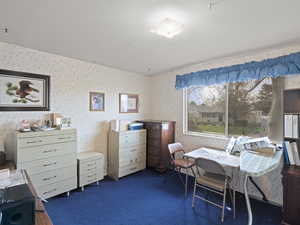 Carpeted home office featuring wallpapered walls