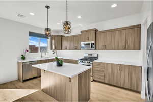 Kitchen with a sink, appliances with stainless steel finishes, a kitchen island, and recessed lighting