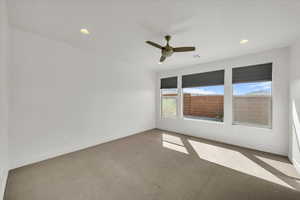 Carpeted spare room featuring visible vents, ceiling fan, recessed lighting, and baseboards