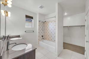 Full bathroom with shower / bath combo, tile patterned flooring, visible vents, and a sink