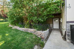 Doorway to property with stucco siding and a yard