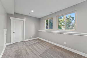 Spare room with recessed lighting, carpet floors, baseboards, and visible vents