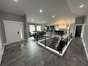 Interior space featuring baseboards, vaulted ceiling, a chandelier, and recessed lighting