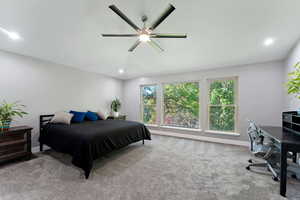 Carpeted bedroom featuring baseboards, ceiling fan, and recessed lighting