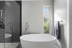 Bathroom featuring a soaking tub and a shower stall
