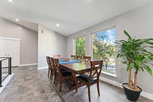 Dining space with plenty of natural light, baseboards, and lofted ceiling