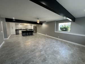 Unfurnished living room with a ceiling fan, recessed lighting, a sink, baseboards, and beam ceiling