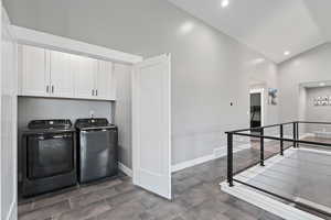 Clothes washing area with baseboards, washing machine and dryer, visible vents, and cabinet space