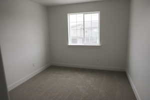 Carpeted spare room with baseboards