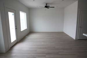 Unfurnished room with baseboards, visible vents, light wood-type flooring, and a ceiling fan