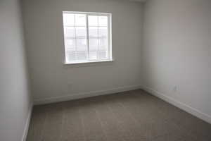 Unfurnished room with baseboards and carpet