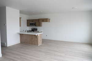 Kitchen featuring light countertops, stainless steel appliances, a sink, visible vents, and a peninsula
