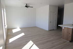 Unfurnished room featuring baseboards, a ceiling fan, and light wood-type flooring