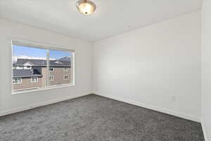 bedroom with dark carpet and baseboards
