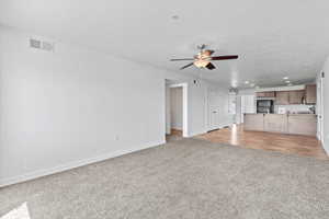 Unfurnished living room with recessed lighting, ceiling fan, and light colored carpet