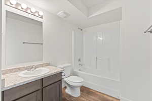 Bathroom with vanity,  shower combination, toilet, and wood finished floors