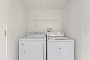 Washroom featuring separate washer and dryer and laundry area