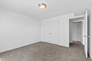 Unfurnished bedroom featuring a closet, carpet flooring