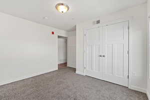 Unfurnished bedroom featuring a closet, , light colored carpet