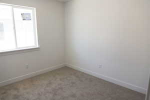 Spare room featuring carpet floors and baseboards